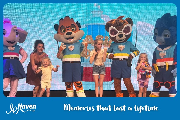 Harley A family standing on stage with some people dressed up as animals facing the camera.